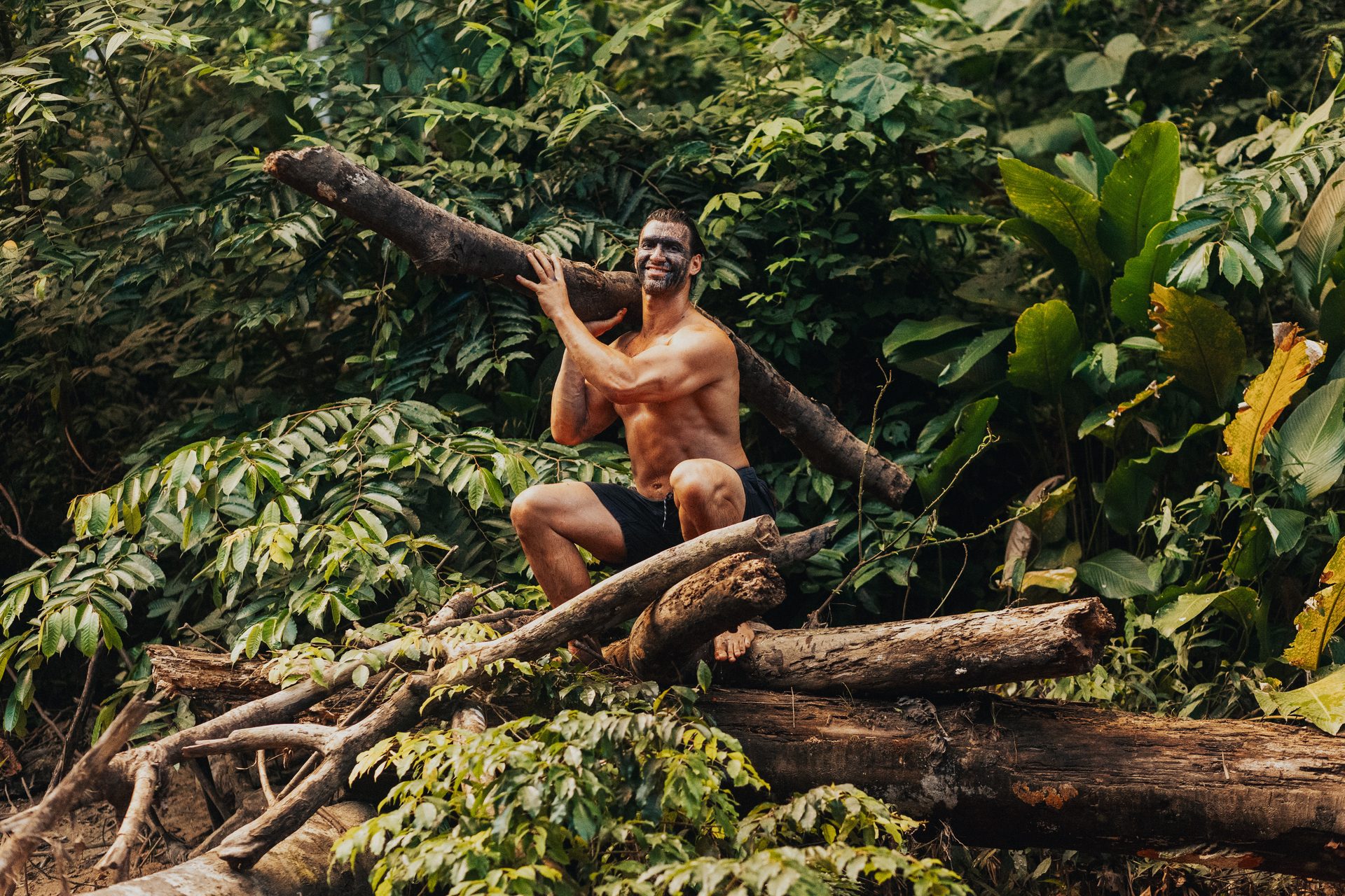 Anthony sitting on a log in the Amazon rainforest