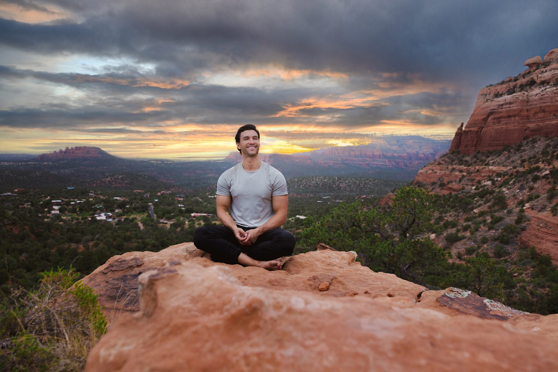 Anthony sitting on a rock at sunset, overlooking the horizon
